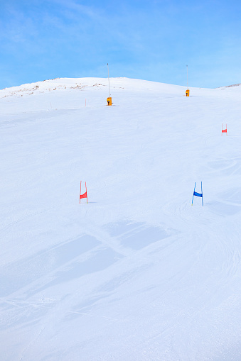 Empty ski racing course with sets of gates. Super G skiing winter sport.  Giant slalom race.  Snow skiing,   perfect ski slope, fresh prepared  piste,  ski resorts.  Snowcapped mountain  Dolomite super ski area. Ski resort. Sellaronda, italy, Europe. No People