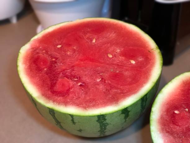 istock Watermelon cut into two halves on a cutting board, close-up 1944715442