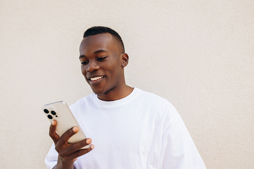 Smiling man using his mobile phone