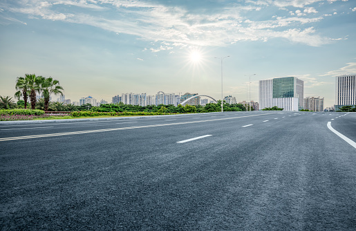 Empty asphalt road and cityscape in summer