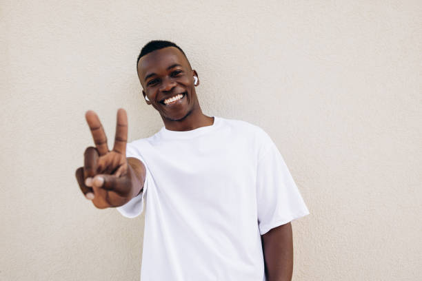 istock Young man wearing wireless earbuds and blank white t-shirt 1944719690