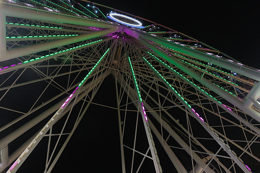 Magdeburg, Germany - 12/10/2022: Ferris wheel at night with lots of lights and a dark black sky in the background