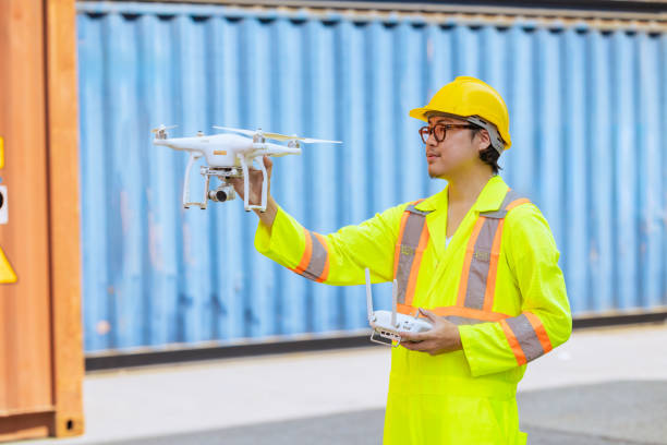 istock Staff worker using Drone aerial imaging system in port container yard. UAV Patrol flying guard technology for survey and security safety area in logistics cargo. 1944746541