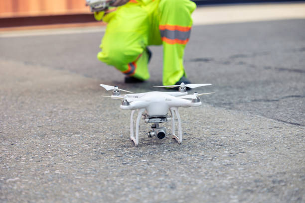 Staff worker using Drone aerial imaging system in port container yard. UAV Patrol flying guard technology for survey and security safety area in logistics cargo.