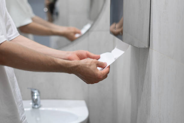 istock A person is captured drying their hands using a paper towel in the clean and well-lit confines of a modern bathroom setting. 1944764735