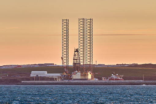 Panoramic view of jack up drilling rig in port during sunset.