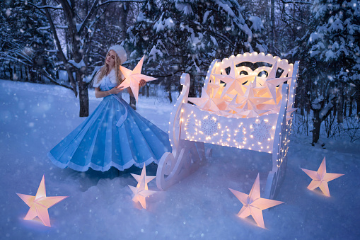 Beautiful woman as snow maiden with sled and stars
