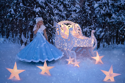 Beautiful woman as snow maiden with sled and stars