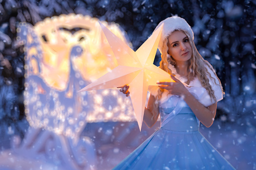 Beautiful woman as snow maiden with sled and stars