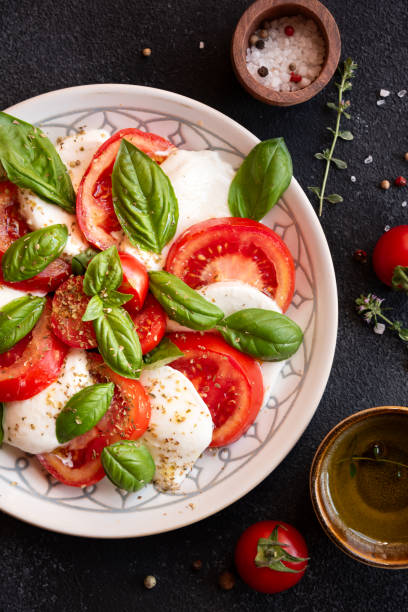 caprese salad with mozzarella cheese and tomatoes of italian cuisine - mozzarella tomato salad italy foto e immagini stock
