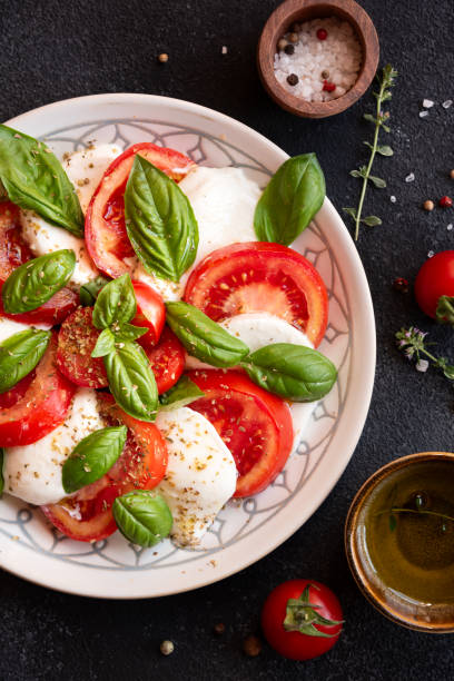 Caprese salad with mozzarella cheese and tomatoes of Italian cuisine