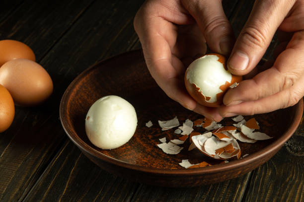 istock Close-up of a man hands holding a boiled egg. Peeling eggs from the shell. Cooking a delicious dinner with boiled eggs. 1944792009