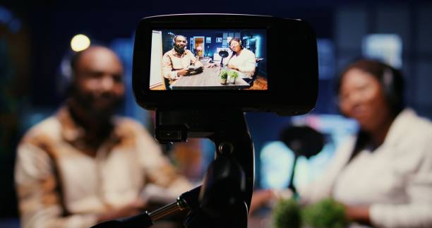istock Focus on vlogging camera used by cohosts in blurry background streaming podcast during live debate 1944794175