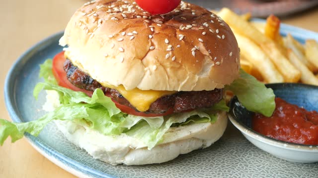 Cheeseburger With Salad And Tomato On a wooden board