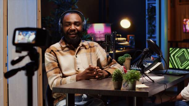 istock Podcast presenter having live discussion with woman, streaming it for audience 1944796273