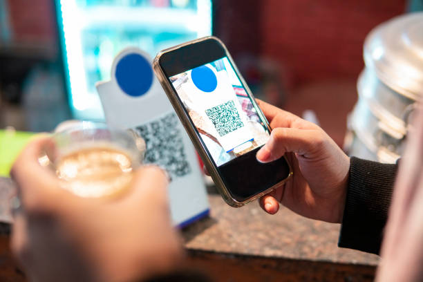 istock Close-up of customer hand scanning QR code with a smartphone for online payment. 1944801904