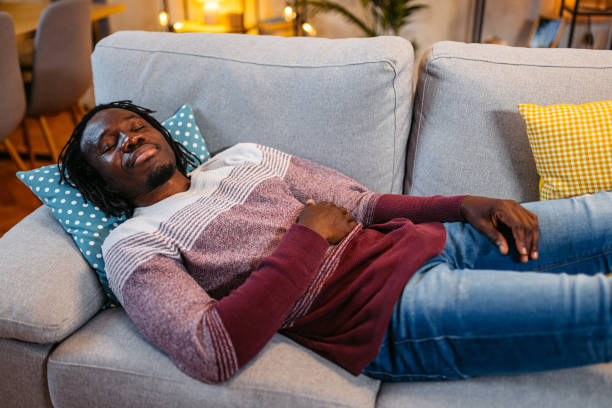istock Young Man Sleeping On The Sofa At Home At Night 1944820330