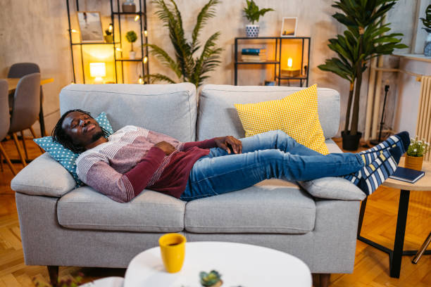 istock Young Man Sleeping On The Sofa At Home At Night 1944824075
