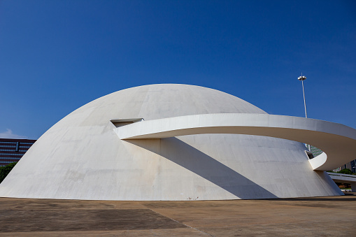 Brasília, Federal District, Brazil – November 26, 2023: A general view of the National Museum of the Republic in the city of Brasília, on a clear, sunny morning with blue skies. The National Museum of the Republic (MuN), opened on December 15, 2006, is part of the Cultural Complex of the Republic and is a Brazilian museum created and administered by the government of the Federal District, Brazil. The architectural project of the building was designed by architect Oscar Niemeyer and is located in Setor Cultural Sul, Lot 2, Esplanada dos Ministérios.