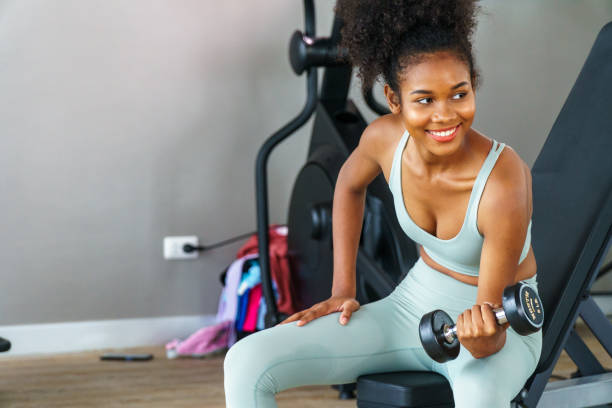 istock black american woman Sitting and exercising by lifting weights. 1944849082