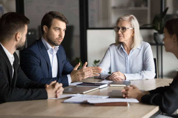 istock Confident project manager man in formal suit speaking to colleagues 1944875540