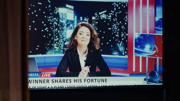 istock Ultrawide modern TV set in empty living room showing reporter presenting news coverage 1944889242
