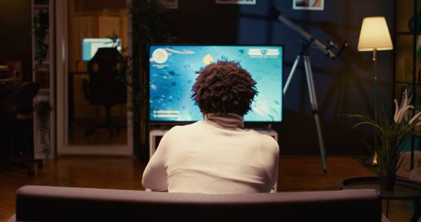 istock Gamer playing classic arcade space shooter videogame on modern smart TV 1944894055
