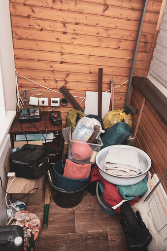 trash and disorder of unnecessary things from the storage area in a container located on the balcony and loggia of the apartment