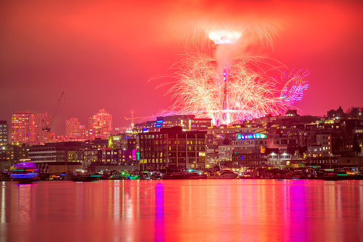 A scenic view of vibrant fireworks illuminate the night sky of Seattle