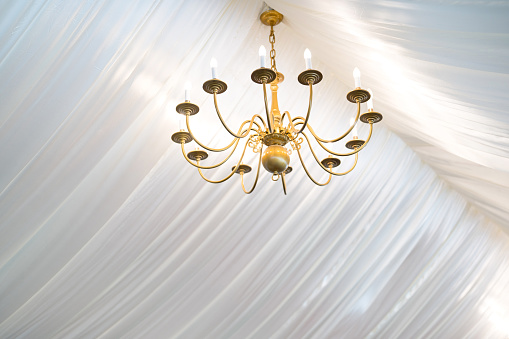 Low-angle view of a beautiful chandelier light hanging on a wedding arch