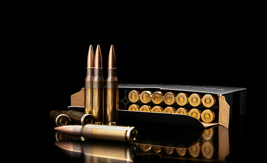 Bullet isolated on black background with reflexion. Rifle bullets close-up on black back. Cartridges for rifle and carbine on a black.