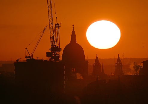 The rising sun behind St Paul's Cathedral and teh City of London skyline