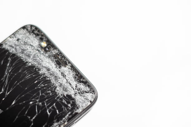 Mobile phone with broken screen on white background.Closeup.Copy space.
