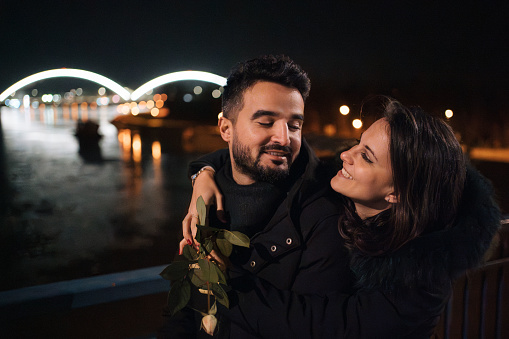 Lovling and happy couple walks over bridge in the middle of the night