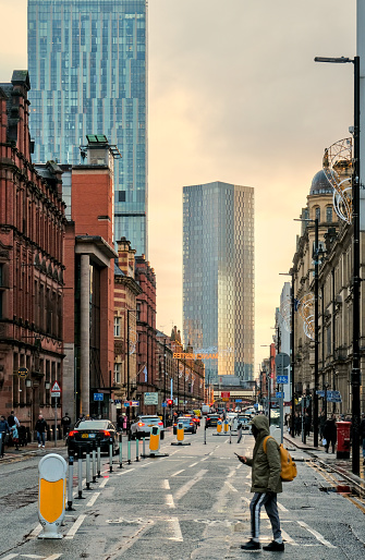 Manchester, United Kingdom - 12 29 2023 : Street scene on Deansgate, including towers and brick wall buildings