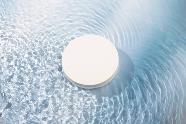 istock blue wave abstract or rippled water texture background. white podium for products display 1945003328