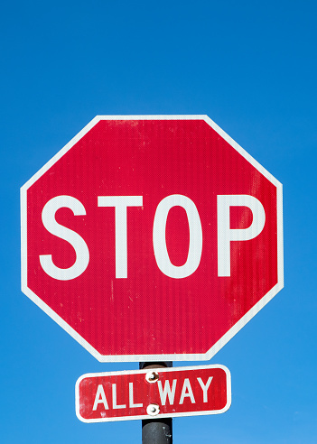Stop sign under blue sky in USA with all way addition, USA