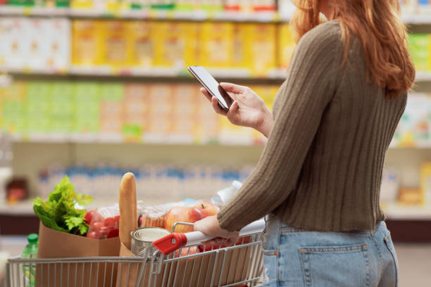 istock Woman using her smartphone at the supermarket 1945017596