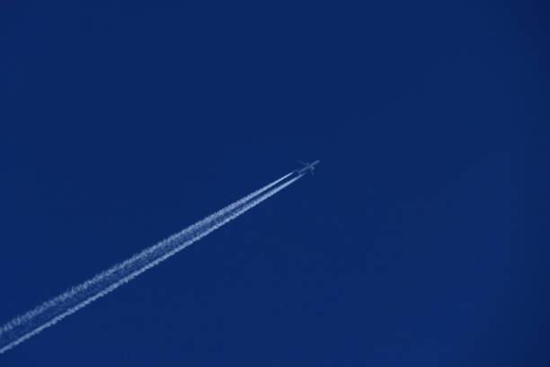 istock airplane in the blue sky, contrail 1945018115