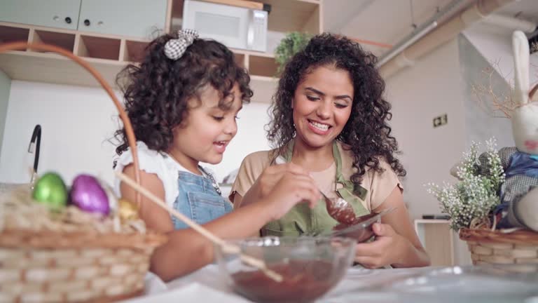 Mother and daughter making chocolate eggs for Easter