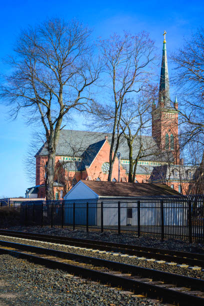 Church and bare trees along the train tracks, winter travel landscape photo in Wallingford, Connecticut, USA