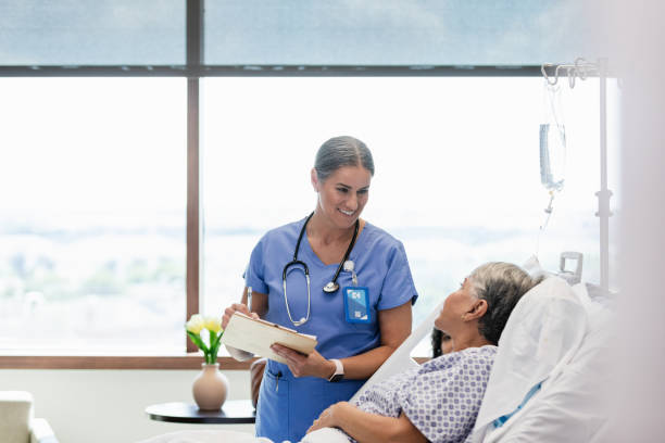 istock Mature female nurse talks with her patient 1945082964