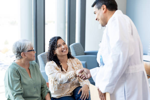 istock Male surgeon greets senior woman's daughter 1945084046