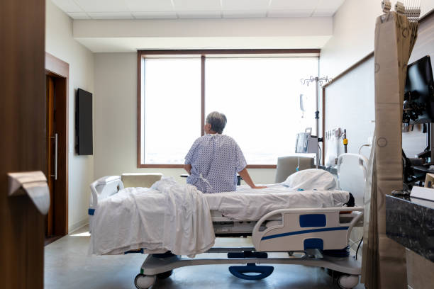 Senior adult woman sits alone in her hospital room The senior adult woman sits alone in her hospital room while she waits for her daughter. Hospital stock pictures, royalty-free photos & images