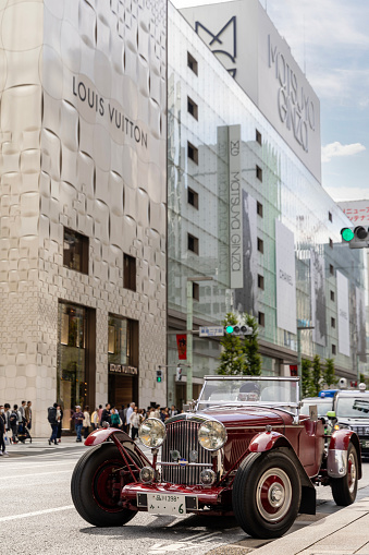 Tokyo, Japan - October 13, 2023: A photograph of a classic and vintage Bentley  speed six collectors car in the busy streets of the famous Chuo-dori high end fashion shopping street of Ginza, in Tokyo, Japan