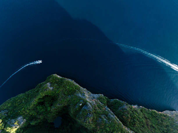 View from above, stunning aerial view of a long tail boat sailing on a blue water near Phi Phi Island. Phuket, Thailand.