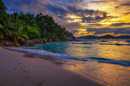 Colorful sunset over Anse Severe Beach at the La Digue Island, Seychelles. This beautiful white-sand beach is famous for its turquoise, shallow waters and sunset views.