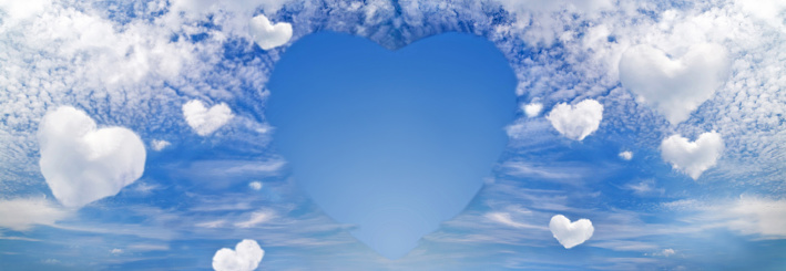 Fluffy clouds forming a hearts shape on blue sky background, soft focus. Heavenly clouds. Holidays of love, Valentine, Mother day, romantic.  Copy space. Empty place for message.