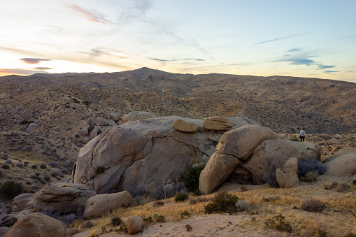 Sun setting behind the Mojave Desert hills and boulders in Apple Valley, CA