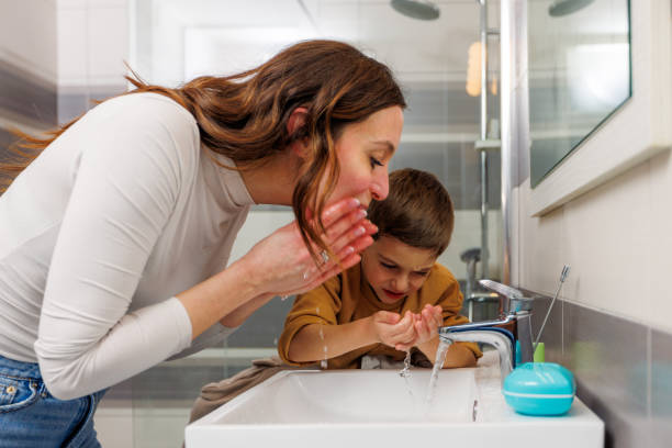 istock Mother And Son Washing Face In The Bathroom 1945170338